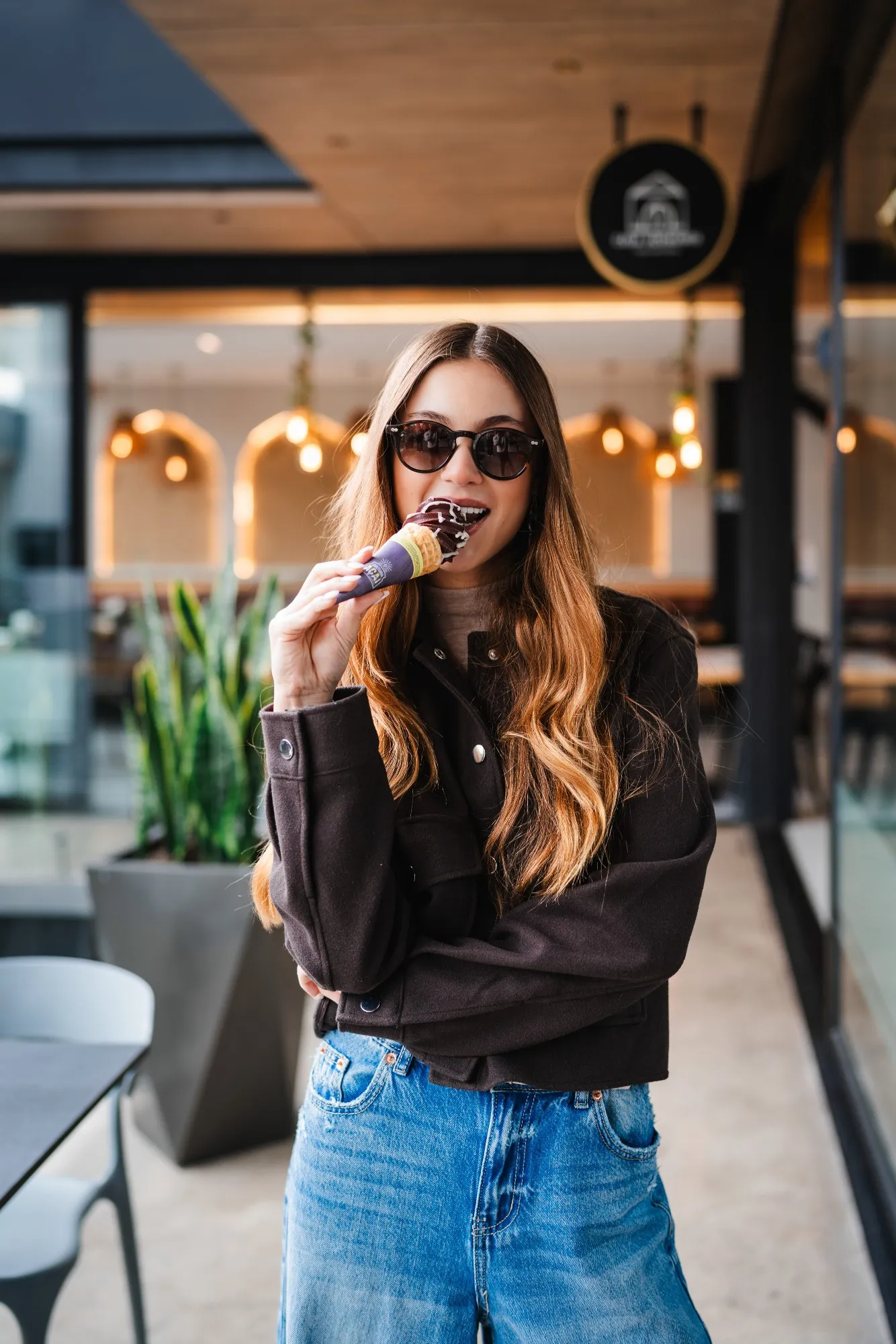 Portraits — mujer con lentes de sol comiendo un helado de açaí