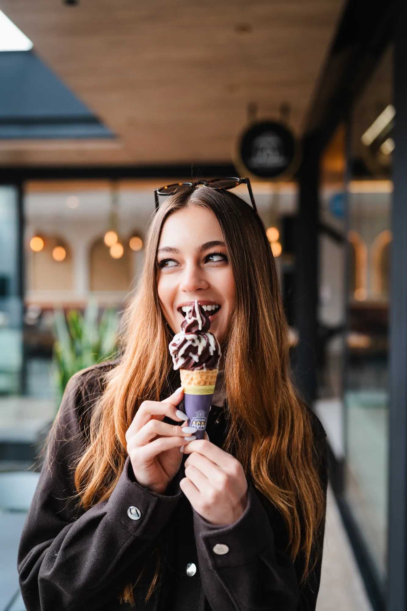 Portraits — mujer sonriendo mientras come un helado de açaí